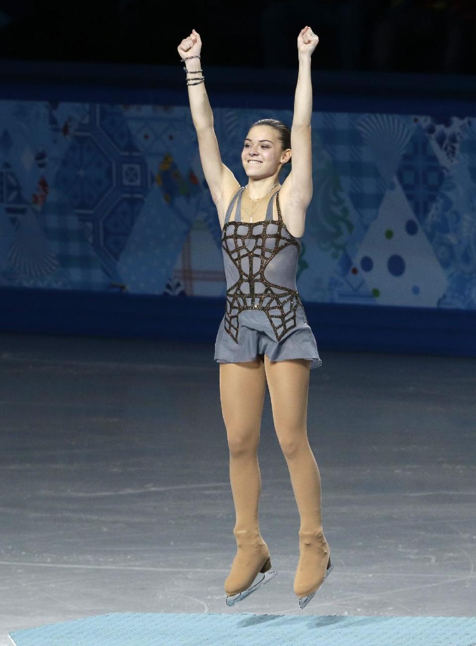 Adelina Sotnikova of Russia jumps on the podium as she celebrates placing first during the flower ceremony for the women's free skate figure skating final at the Iceberg Skating Palace during the 2014 Winter Olympics, Thursday, Feb. 20, 2014, in Sochi, Russia. (AP Photo/Darron Cummings)