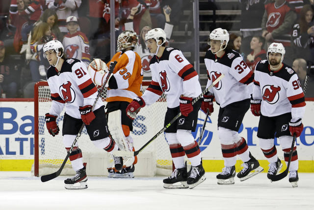 The 2003 Stanley Cup Champion New Jersey Devils pose for a team photo after  a ceremony honoring the 20-year anniversary before an NHL hockey game  against the Philadelphia Flyers, Saturday, Feb. 25