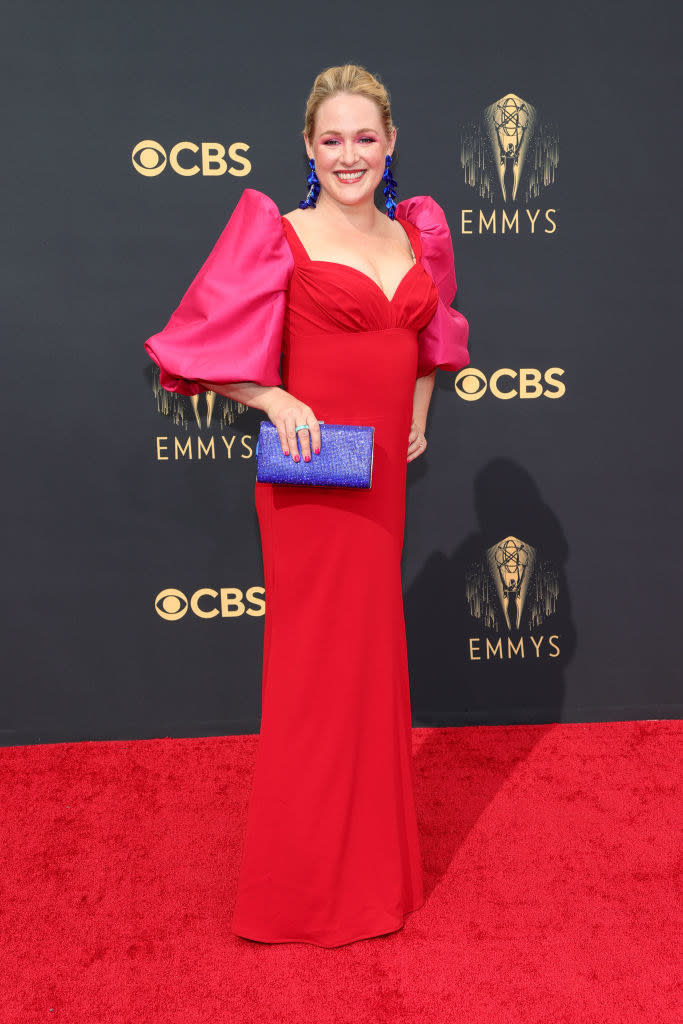 Ariel Dumas on the red carpet in a red gown with bright pink puffy sleeves