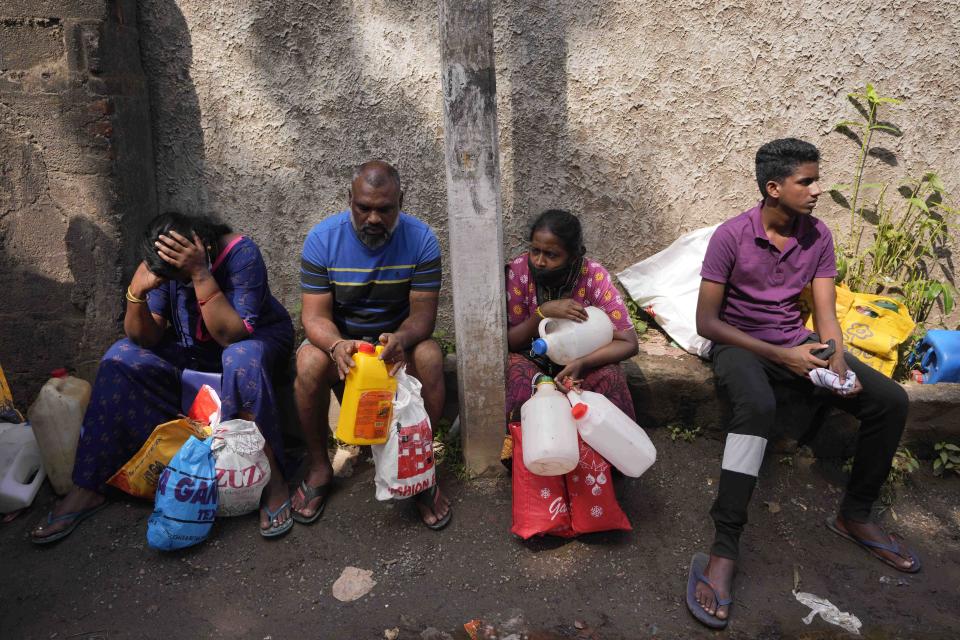 Sri Lankans wait in a queue to buy kerosene oil for cooking outside a fuel station in Colombo, Sri Lanka, Wednesday, May 11, 2022. Sri Lanka's defense ministry ordered security forces on Tuesday to shoot anyone causing injury to people or property to contain widespread arson and mob violence targeting government supporters.(AP Photo/Eranga Jayawardena)