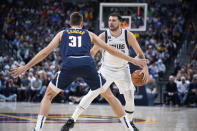 El jugador de los Mavericks de Dallas Luka Doncic, al fondo, es defendido por el jugador de los Nuggers de Denver Vlatko Cancar en la primera mitad de su juego de NBA el martes 6 de diciembre de 2022 en Denver. (AP Foto/David Zalubowski)