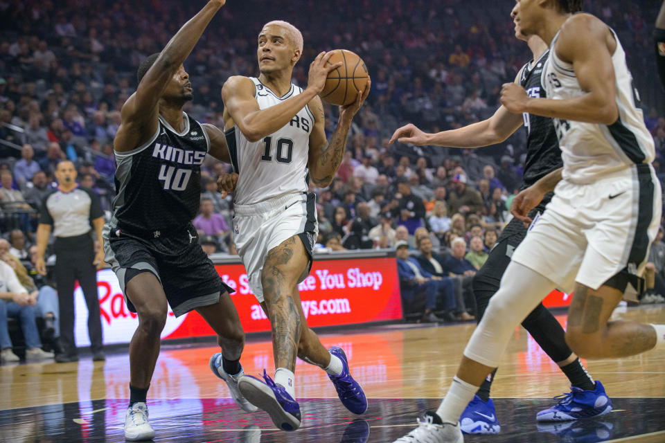 San Antonio Spurs forward Jeremy Sochan (10) drives past Sacramento Kings forward Harrison Barnes (40) during the first quarter of an NBA basketball game in Sacramento, Calif., Thursday, Nov. 17, 2022. (AP Photo/Randall Benton)