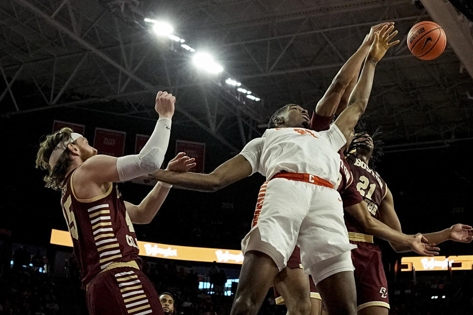 Clemson forward Chauncey Wiggins (21) and Boston College forward Devin McGlockton (21) chase a rebound during the first half of an NCAA college basketball game, Saturday, Jan. 13, 2024, in Clemson, S.C. (AP Photo/Mike Stewart)