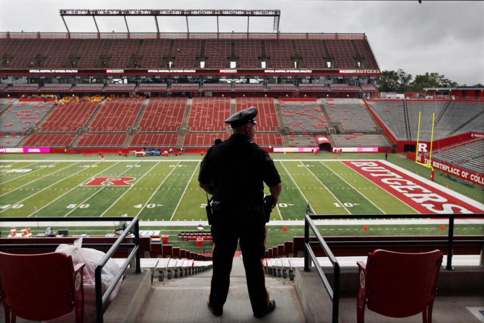 A police officer looks out on a wet field at Rutgers football stadium before an NCAA college football game between Rutgers and Penn State, Saturday, Sept. 13, 2014, in Piscataway, N.J. (AP Photo/Mel Evans)