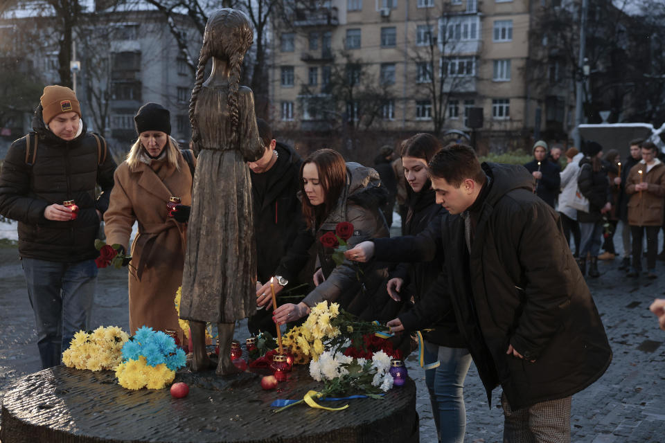 People pray, lay flowers and light candles at Holodomor Genocide Museum, which commemorates the 