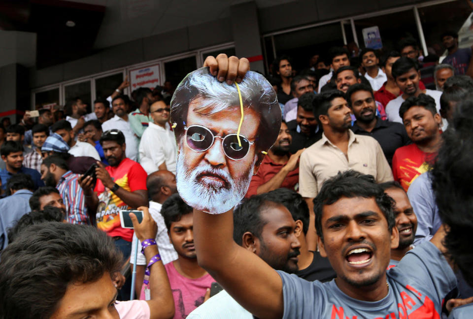 <p>A fan holds a mask of Indian superstar Rajinikanth as he leaves with others after watching the actor’s new movie 'Kabali’ at a cinema hall in Chennai, India, Friday, July 22, 2016. Hundreds of thousands of Rajinikanth fans thronged cinemas across Tamil-language India and Malaysia to catch the pre-dawn showing of “Kabali,” a gangster movie that left patrons jumping from their seats and dancing in the aisles at the sight of their hero. (AP Photo/Aijaz Rahi)</p>