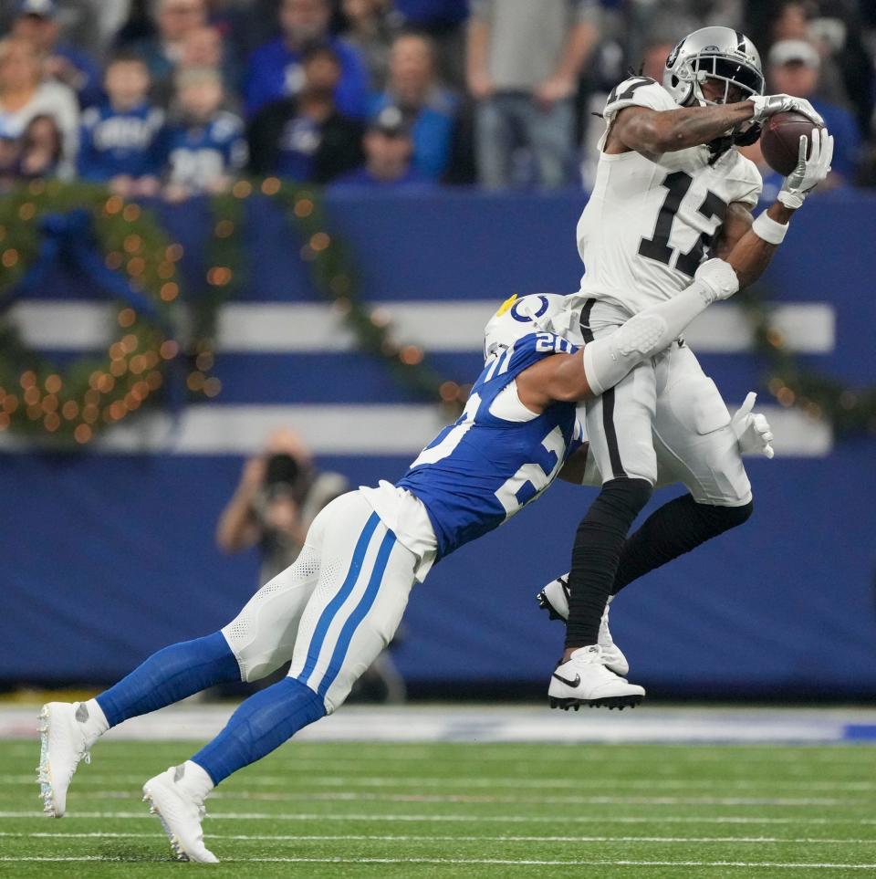 Indianapolis Colts safety Nick Cross (20) wraps up Las Vegas Raiders wide receiver Davante Adams (17) as he makes a catch Sunday, Dec. 31, 2023, during a game against the Las Vegas Raiders at Lucas Oil Stadium in Indianapolis.