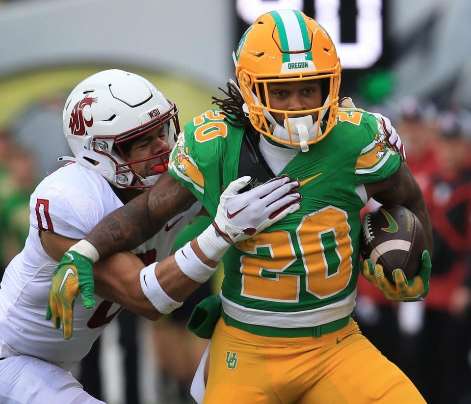 Oregon’s Jordan James, right, breaks into the open for a big gain against Washington State’s Sam Lockett III during the second quarter at Autzen Stadium Saturday, Oct. 21, 2023.