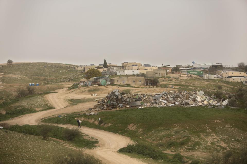 In this Sunday, March 12, 2017 photo, a man walks near the debris of demolished homes, in the Bedouin village of Umm al-Hiran, Israel. The deadly shooting of Yaakub Abu al-Qiyan in Umm al-Hiran by Israeli police during home demolitions in the Negev desert in January, which officials say might have been a mistake, has strained ties between the government and Israel’s Arab minority. Residents of Umm al-Hiran say the court-ordered evacuation was just the latest instance of decades of mistreatment toward the formerly nomadic Bedouin, who are now Israeli citizens. (AP Photo/Sebastian Scheiner)
