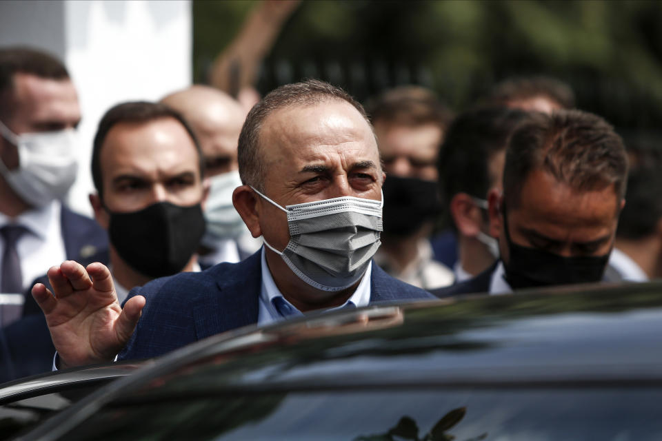 Turkish Foreign Minister Mevlut Cavusoglu, center, leaves a muslim cemetery at Komotini town, in northeastern Greece, Sunday, May 30, 2021. Greece's prime minister said Friday his country is seeking improved ties with neighbor and longtime foe Turkey, but that the onus is on Turkey to refrain from what he called "provocations, illegal actions and aggressive rhetoric." (AP Photo/Giannis Papanikos)
