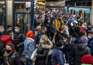 People wear face masks but stand close together as they wait for a subway train in Frankfurt, Germany, Wednesday, Dec. 2, 2020. (AP Photo/Michael Probst)