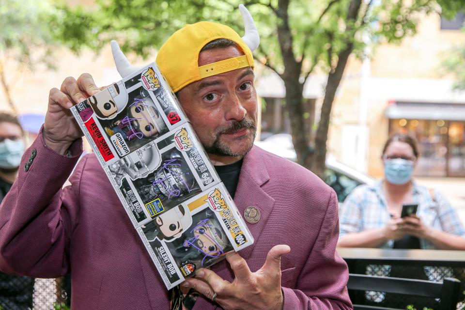 Filmmaker and actor Kevin Smith, holds up signed collectibles at the grand-opening of the Austin location for "Mooby's," on May 10, 2021. Mooby's is a restaurant experience based on a fictional fast food restaurant that appears in several Kevin Smith films like "Dogma" and "Clerks II." The restaurant experience is officially called Mooby's Pop Up Restaurant and Bar and is a cross-country tour that takes over live music venues that Smith invented as a way to support the music industry after a year of severe limitations.