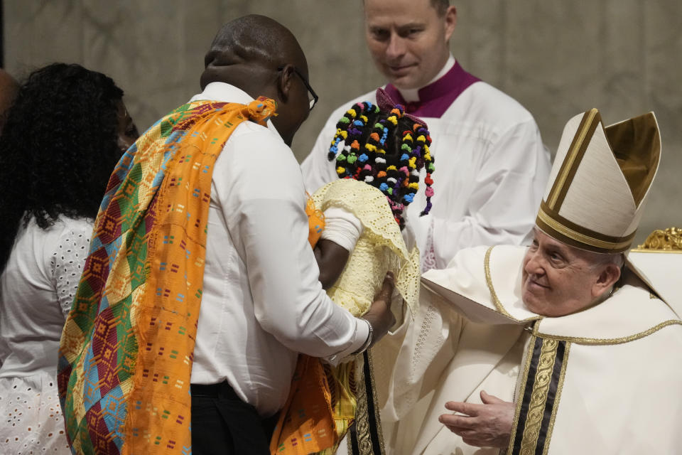 Pope Francis blesses a family as he presides over Christmas eve Mass, at St. Peter's Basilica at the Vatican, Sunday Dec. 24, 2023. (AP Photo/Gregorio Borgia)