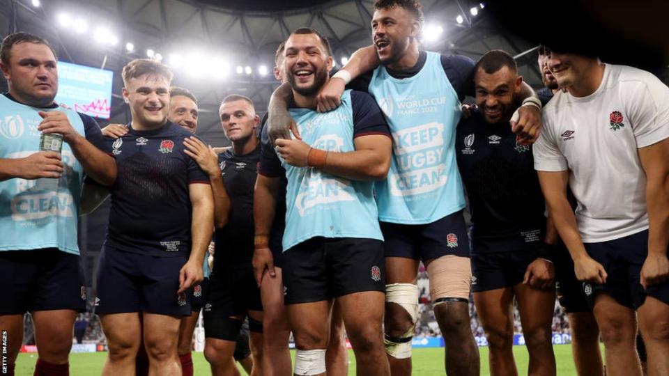 Ellis Genge and Courtney Lawes share a joke with their team in the post-match huddle against Argentina