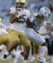 Notre Dame's Chris Tyree (25) spins away from North Carolina's British Brooks (34) in the second quarter of an NCAA college football game, Friday, Nov. 27, 2020, at Kenan Stadium in Chapel Hill, N.C. (Robert Willett/The News & Observer via AP)