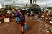 <p>A woman gestures as a car is removed from the road in the town of Mandra, northwest of Athens, on Nov. 15, 2017, after heavy overnight rainfall in the area caused damage and left seven people dead. (Photo: Valerie Gache/AFP/Getty Images) </p>