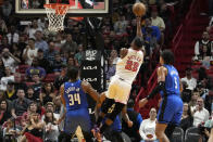 Miami Heat forward Jimmy Butler (22) goes to t he basket between Orlando Magic center Wendell Carter Jr. (34) and forward Paolo Banchero (5) during the first half of an NBA basketball game, Friday, Jan. 27, 2023, in Miami. (AP Photo/Lynne Sladky)