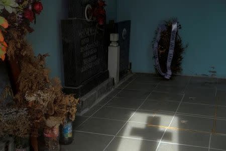 A cross casts a shadow inside a chapel at a cemetery in the village of Sapine, Serbia, October 25, 2016. REUTERS/Marko Djurica