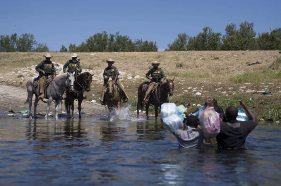 Mounted U.S. Border Patrol agents stop Haitian migrants crossing the Rio Grande in Del Rio, Texas, on Sunday.