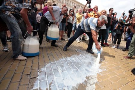 Protesters dump milk during a rally against the government-ordered mass slaughter of sheep and goats following the first outbreak in the European Union of the highly contagious Peste des Petits Ruminants (PPR) in Sofia, Bulgaria, July 18, 2018. REUTERS/Dimitar Kyosemarliev