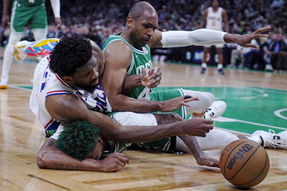 Philadelphia 76ers center Joel Embiid battles for a loose ball with Boston Celtics center Al Horford, right, and guard Marcus Smart, bottom, during the second half of Game 2 in the NBA basketball Eastern Conference semifinals playoff series, Wednesday, May 3, 2023, in Boston. (AP Photo/Charles Krupa)