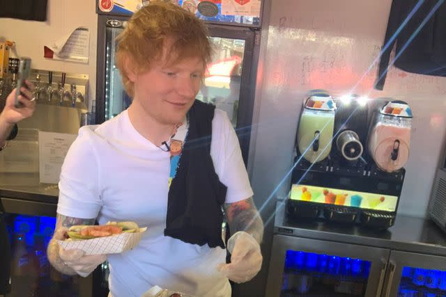 <p>twitter</p> Ed Sheeran serving Chicago-style hot dogs to fans at The Weiners Circle.