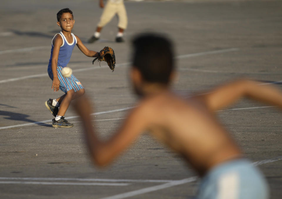 In this July 8, 2013 photo, children play baseball near the Latinoamericano Stadium in Havana, Cuba. For a place where most people earn just $20 a month at their government jobs, Havana can be a surprisingly expensive place to be a traveler. But there are plenty of free ways to have fun in this city known for sea, sun and salsa. (AP Photo/Franklin Reyes)