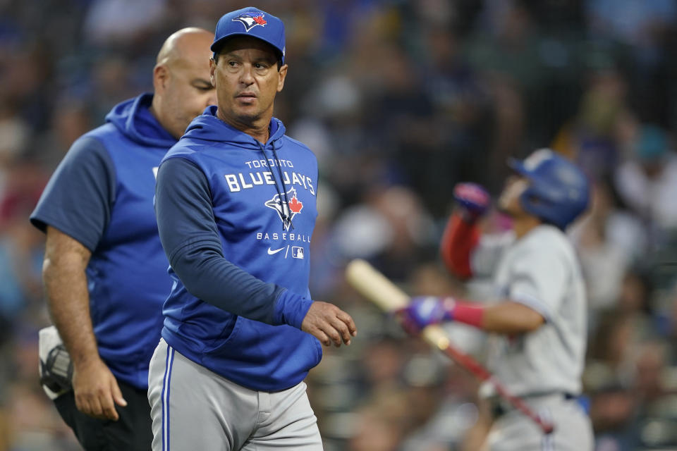 Toronto Blue Jays manager Charlie Montoyo walks with a trainer after Bradley Zimmer was hit by a pitch during the seventh inning of the team's baseball game against the Seattle Mariners, Thursday, July 7, 2022, in Seattle. Zimmer stayed in the game. (AP Photo/Ted S. Warren)