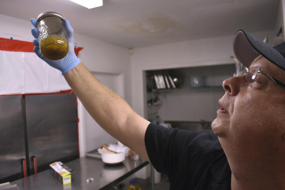 Montana Advanced Caregivers owner Richard Abromeit holds up a jar containing almost pure THC that has been extracted from marijuana at the Billings, Mont., medical marijuana dispensary on Nov. 11, 2020. He credits passage of a recreational marijuana initiative to a years-long campaign to educate the public about the benefits of cannabis. (AP Photo/Matthew Brown)