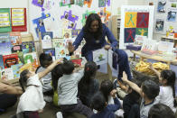 Former first lady Michelle Obama reads a book to school children during a surprise appearance at Para Los Niños on Thursday, Nov. 15, 2018, in Los Angeles. (Photo by Willy Sanjuan/Invision/AP)