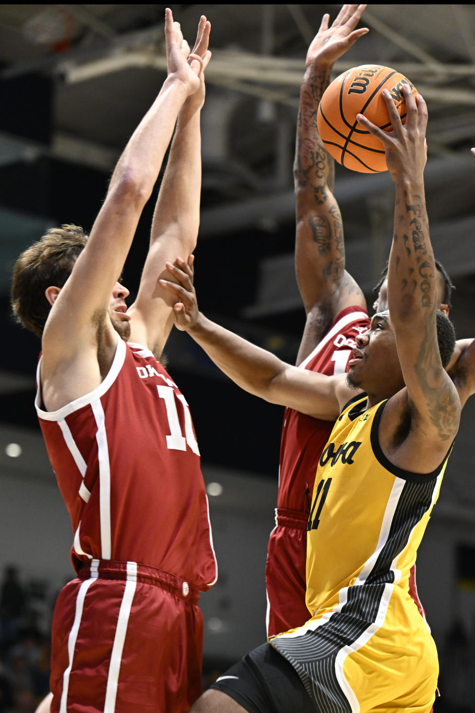 Iowa guard Tony Perkins (11) shoots over Oklahoma forward Sam Godwin (10) during the first half of an NCAA college basketball game Thursday, Nov. 23, 2023, in San Diego. (AP Photo/Denis Poroy)