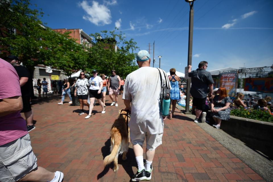 Scott Hegle and his guide dog, Lumiere, navigate through crowds at the CMA Fest in Nashville, Tenn., Saturday, June 11, 2022.
