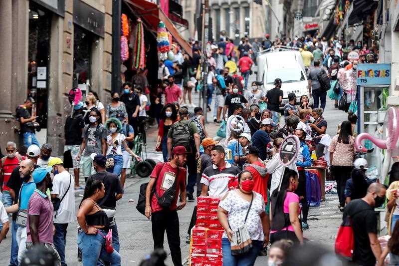 Dozens of people walk on a busy commercial street in the centre of Sao Paulo, Brazil.