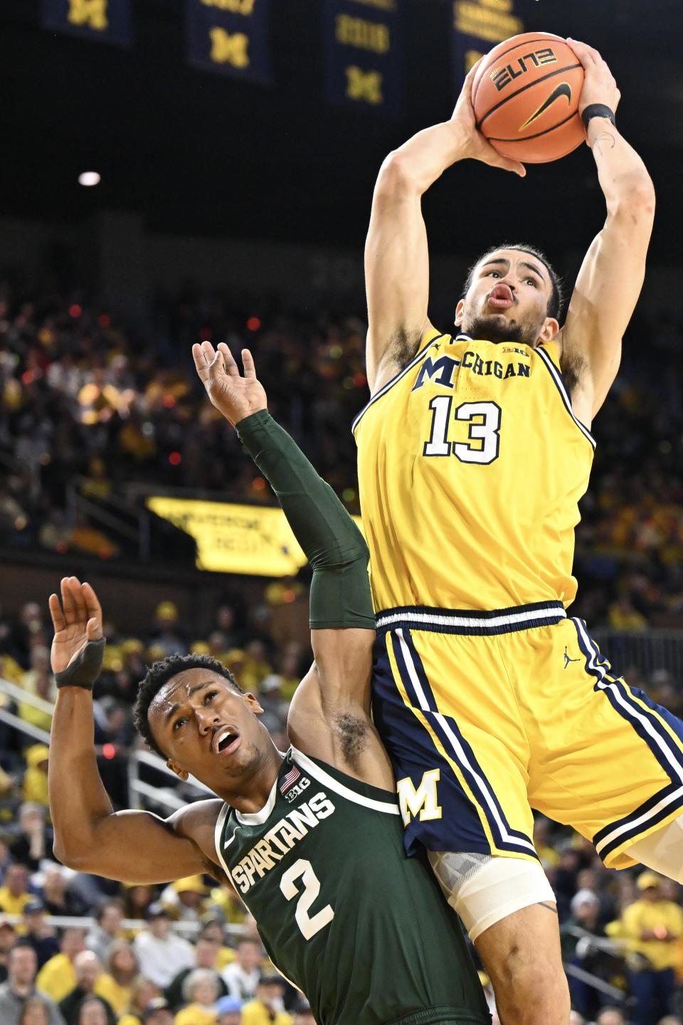 Olivier Nkamhoua of the Michigan Wolverines shoots over Tyson Walker of the Michigan State Spartans during the first half at Crisler Center in Ann Arbor on Saturday, Feb. 17, 2024.