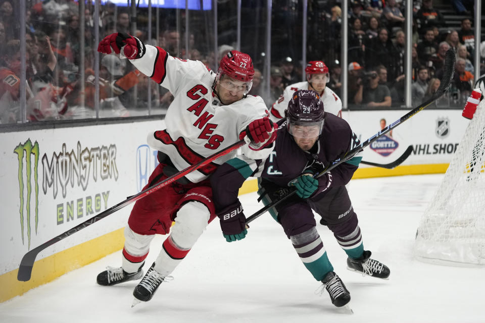 Carolina Hurricanes' Brett Pesce (22) and Anaheim Ducks' Mason McTavish (23) chase the puck during the third period of an NHL hockey game, Sunday, Oct. 15, 2023, in Anaheim, Calif. (AP Photo/Jae C. Hong)