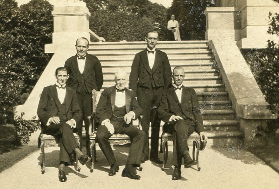 This circa 1920s photo provided by The Preservation Society of Newport County shows butler Ernest Birch, center, surrounded by footmen next to the terrace of The Elms mansion in Newport, R.I.  Newly discovered photographs, documents and family histories have inspired the creation of a tour about servants at The Elms, echoing themes of the British drama program, "Downton Abbey."  (AP Photo/The Preservation Society of Newport County)