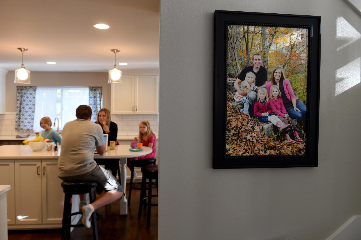 Alissa and Robbie Parker and their children sit in their kitchen. A family photo is seen on the wall next to the kitchen.