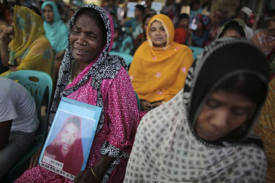 A relative of a garment worker, who went missing in the Rana Plaza collapse, mourns as she waits for a mass prayer on the first year anniversary of the accident, at a school in Savar