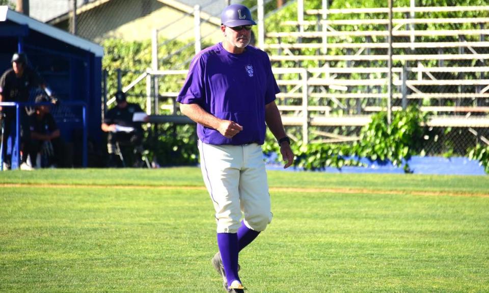 Livingston High baseball coach Matt Winton makes his way back to the dugout after making a pitching change during a game against Enochs on Tuesday, April 2, 2024 at Memorial Ballpark in Atwater, Calif.