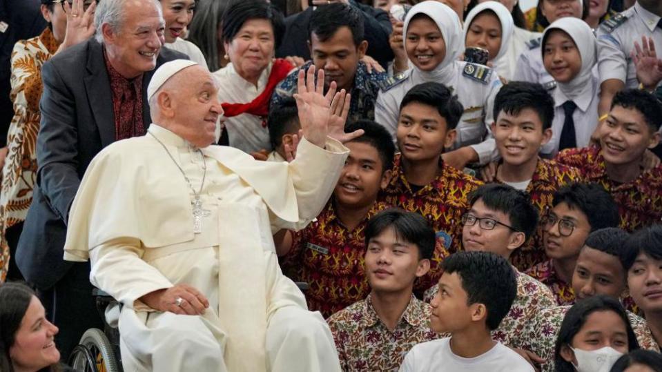 Pope Francis (4L) waves to people as Jose Maria del Corral, president of Scholas Occurrentes (3L), looks on at the Grha Pemuda Youth Center in Jakarta on September 4, 2024.