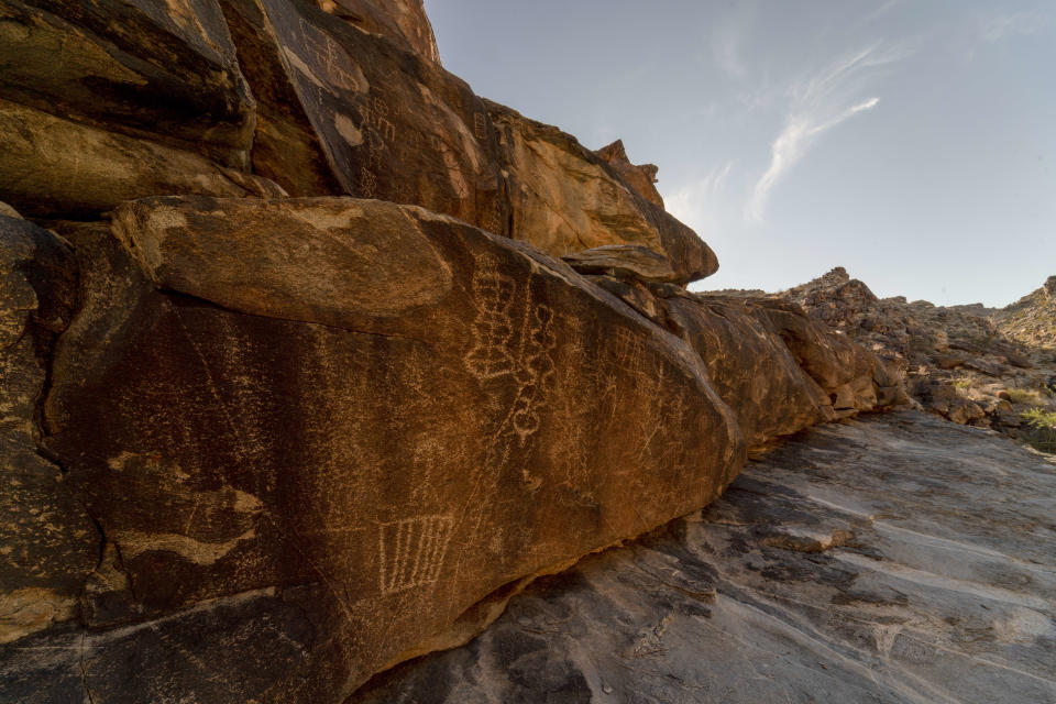 Petroglyphs on the rock face in Hiko Springs Canyon include a rectangle with five bars and two vertical rows of interlocking lozenges.