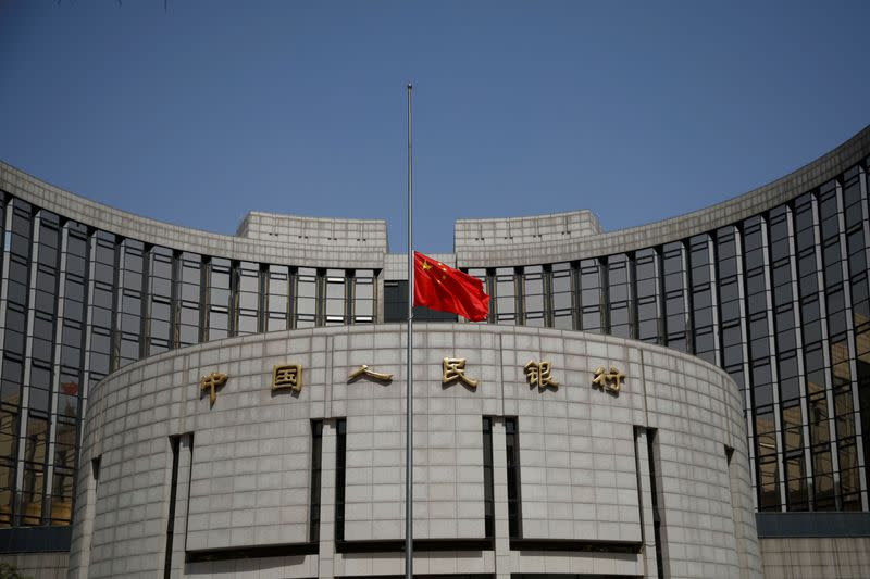 La bandera nacional china ondea a media asta en la sede del Banco Popular de China, el banco central (PBOC), mientras China celebra un luto nacional por los que murieron de la enfermedad coronavirus (COVID-19), en Pekín