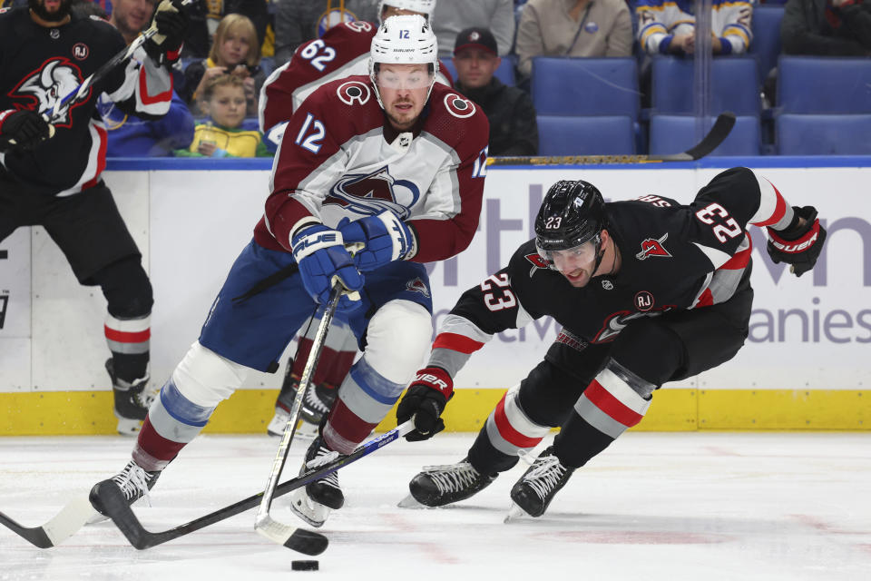 Colorado Avalanche center Ryan Johansen (12) is stick-checked by Buffalo Sabres defenseman Mattias Samuelsson (23) during the second period of an NHL hockey game, Sunday, Oct. 29, 2023, in Buffalo, N.Y. (AP Photo/Jeffrey T. Barnes)