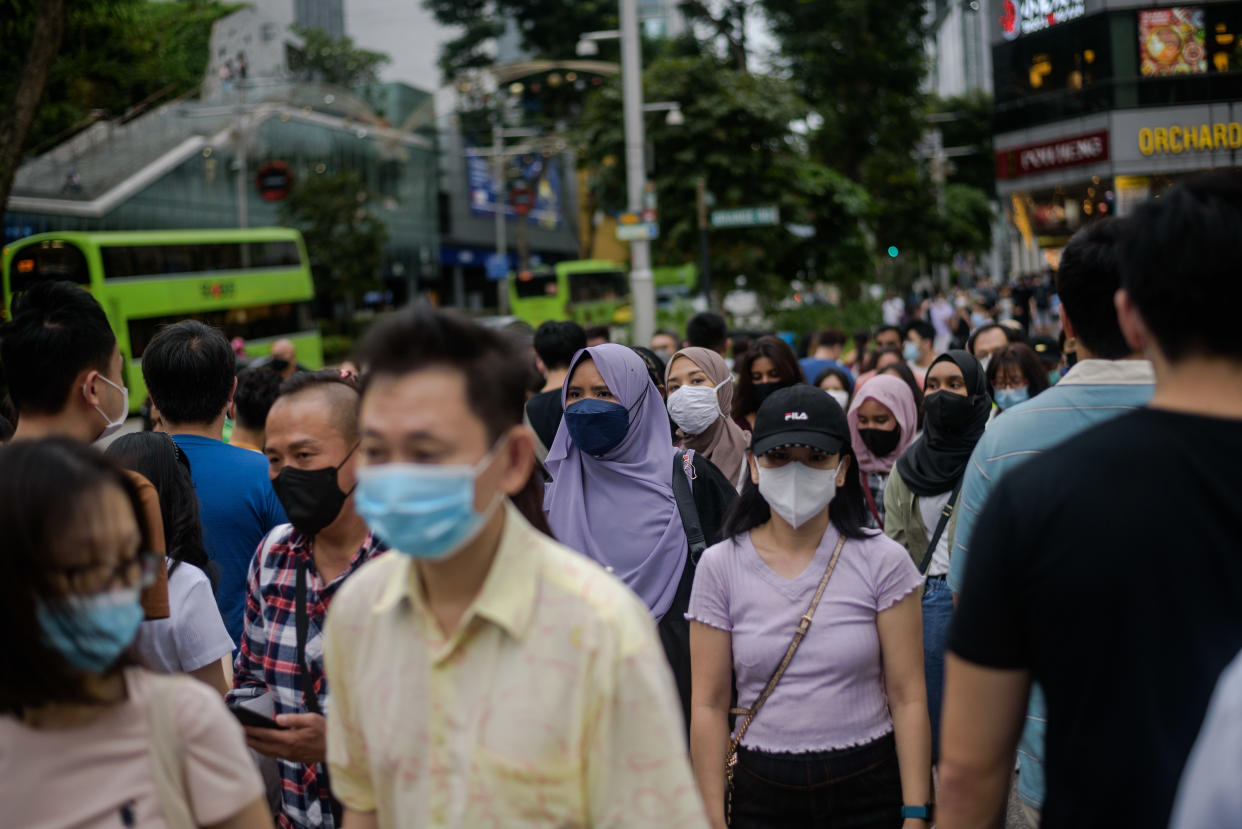 Crowds cross the street in Singapore's Orchard Road shopping district on Sunday, 12 December 2021. (Photo by Joseph Nair/NurPhoto via Getty Images)