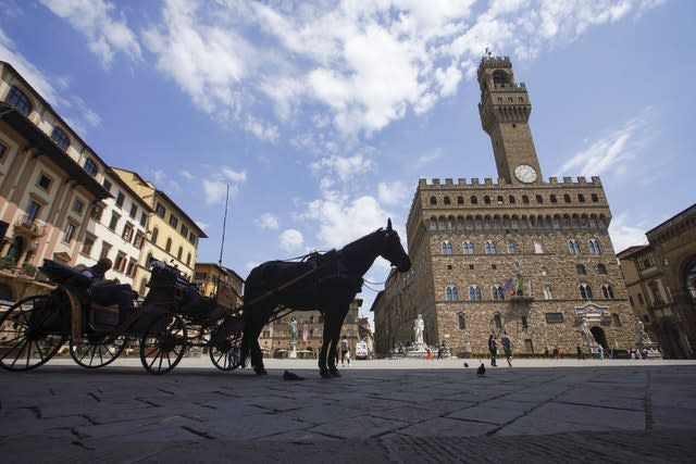 A horse-driven carriage waits for customers in an unusually uncrowded historical Piazza della Signoria square, in Florence (Andrew Medichini/AP)