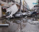 Piled up vehicles are pictured on a flooded street filled with debris after Typhoon Haiyan hit the central Philippine city of Tacloban, Leyte province in this still image from video November 8, 2013. Typhoon Haiyan, possibly the strongest storm ever to hit land, has devastated Tacloban, killing at least 100 people and destroying most houses in a surge of flood water and high winds, officials said on Saturday. The toll of death and damage is expected to rise sharply as rescue workers and soldiers reach areas cut off by the massive storm, now barrelling out of the Philippines towards Vietnam. REUTERS/GMA News via Reuters TV (PHILIPPINES - Tags: DISASTER TRANSPORT ENVIRONMENT) ATTENTION EDITORS - THIS IMAGE WAS PROVIDED BY A THIRD PARTY. FOR EDITORIAL USE ONLY. NOT FOR SALE FOR MARKETING OR ADVERTISING CAMPAIGNS. NO SALES. NO ARCHIVES. THIS PICTURE IS DISTRIBUTED EXACTLY AS RECEIVED BY REUTERS, AS A SERVICE TO CLIENTS. PHILIPPINES OUT. NO COMMERCIAL OR EDITORIAL SALES IN PHILIPPINES. MANDATORY CREDIT TO GMA NEWS