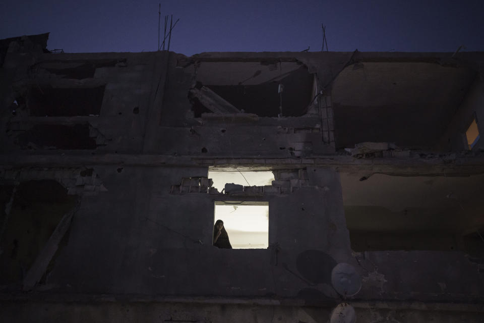 A room in the heavily damaged Nassir home is illuminated at night by a lamp, using electricity from a neighbor, in Beit Hanoun, northern Gaza Strip, Friday, June 11, 2021. (AP Photo/Felipe Dana)