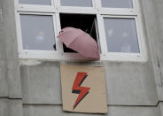 People signal support from their windows to a protest for women's rights in Warsaw, Poland, Wednesday Oct. 28, 2020. Both the umbrella and the lightning strike have become symbols of women's struggle for reproductive rights in Poland. People across Poland stayed off their jobs and crowds gathered for a seventh straight day of street protests on Wednesday in a mass outpouring of anger at a top court ruling that bans abortions in cases of congenitally damaged fetuses.(AP Photo/Czarek Sokolowski)