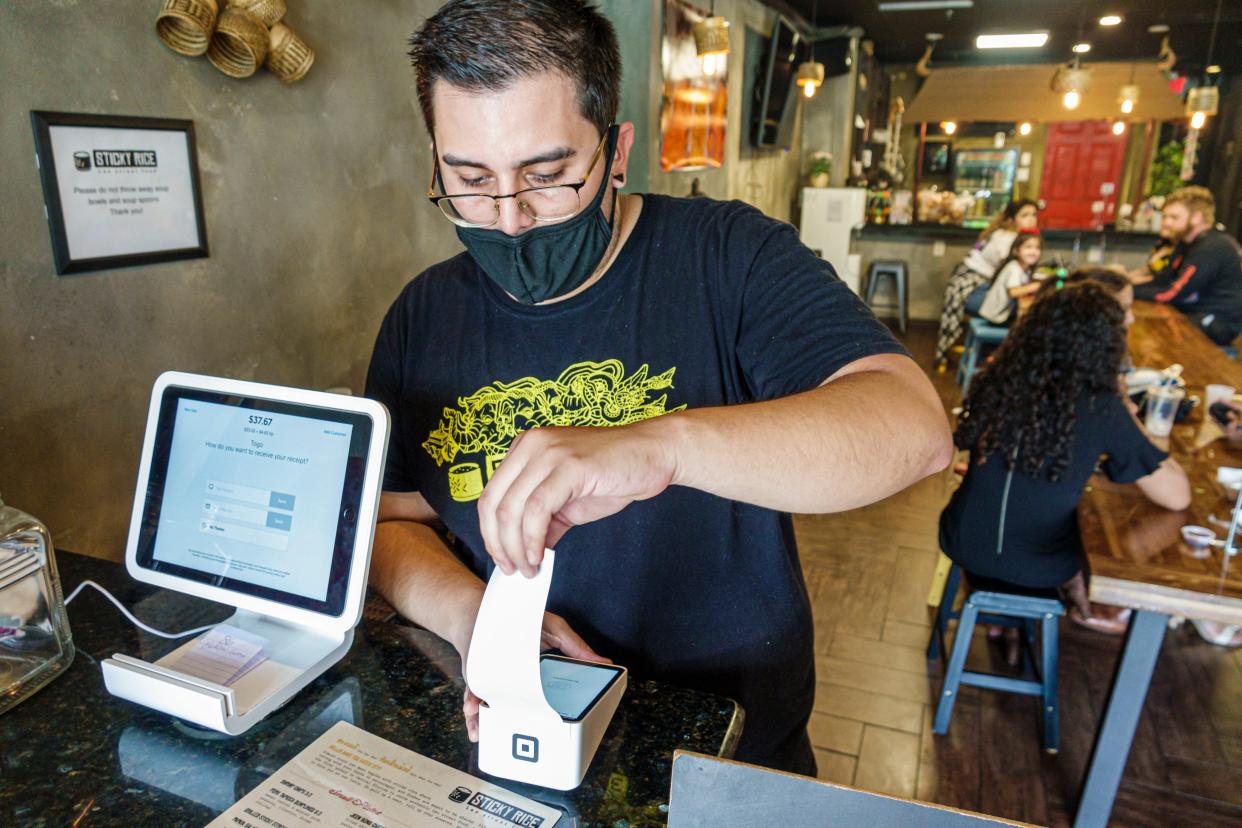 Cafe employee processes credit card payment with Square