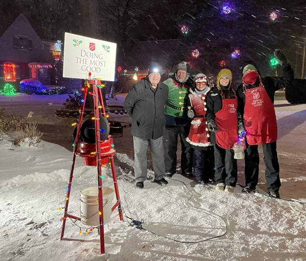 A group of bell-ringers are shown near a Salvation Army red kettle during a past campaign in Sherman Woods. Local lighting tours take visitors past bell-ringers this time of year.